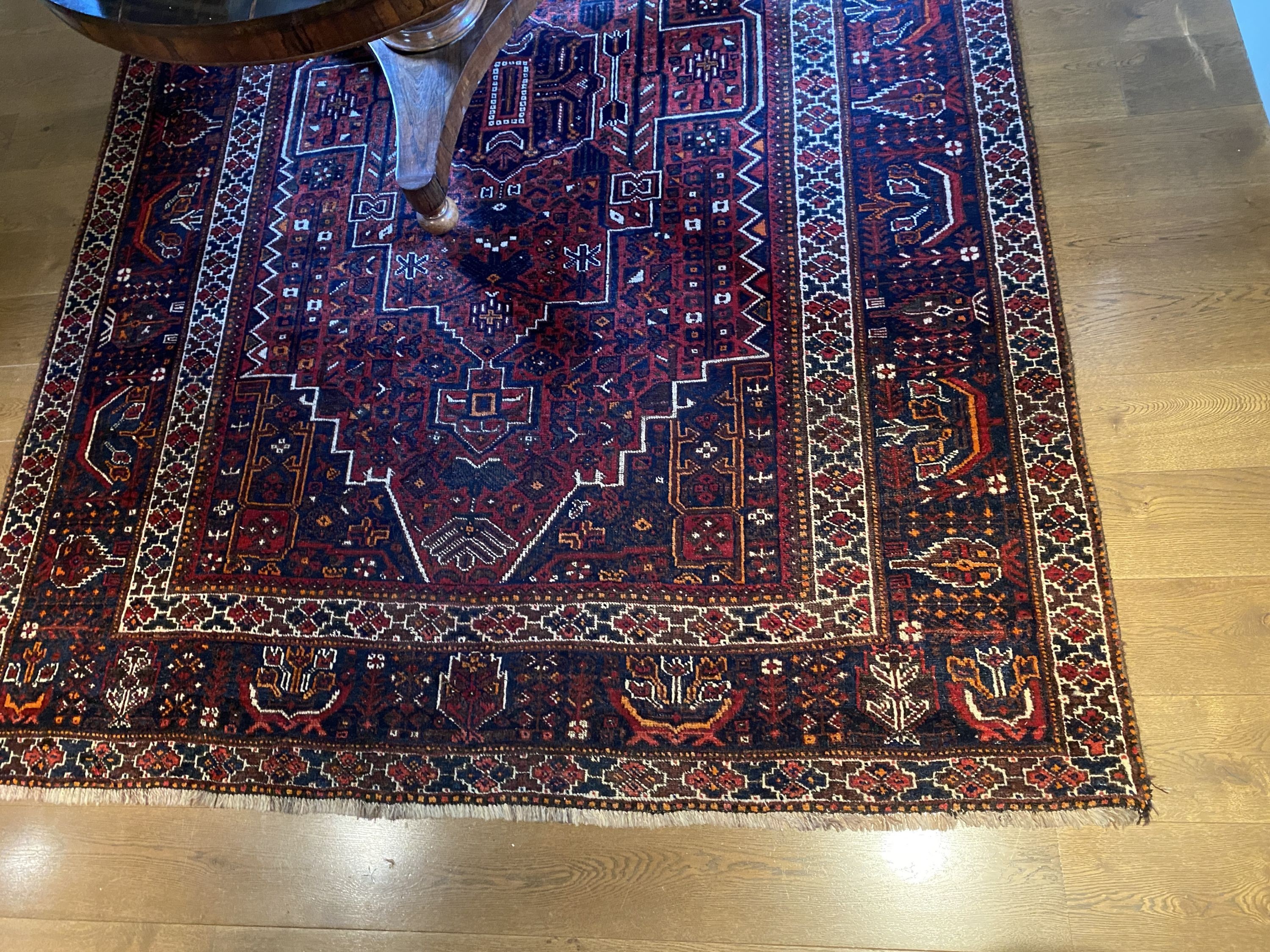 A Caucasian red ground carpet, decorated with foliate motifs, multi-bordered and signed in one corner, 300 x 208cm